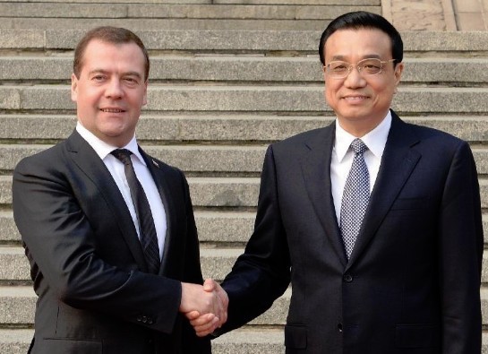 Chinese Premier Li Keqiang (R) shakes hands with his Russian counterpart Dmitry Medvedev during a welcoming ceremony for Medvedev before they co-chair the 18th regular meeting between the Chinese and Russian heads of government in Beijing, capital of China, Oct. 22, 2013. (Xinhua/Liu Jiansheng) 