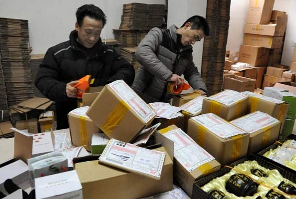 Staff members with a postal delivery company prepare packages in Yiwu, Zhejiang province. A Chinese express courier, Yuantong Express, may lose clients after media reports that personal information about its customers was sold online. ZHANG JIANCHENG / FOR CHINA DAILY