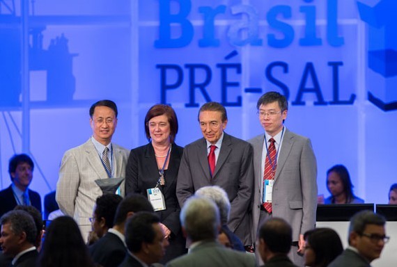 Representatives of China National Offshore Oil Corp and China National Petroleum Corp flank Brazilian officials after a bidding ceremony on Oct 21 for a 35-year production sharing contract to develop Libra, a deepwater oilfield off the coast of Rio de Janeiro. [Photo/Xinhua]  