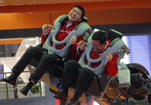   Visitors have fun with a robot Robocoaster from Germany at China International Industry Fair in Shanghai, on Nov 5, 2013. [Photo/China Daily]   