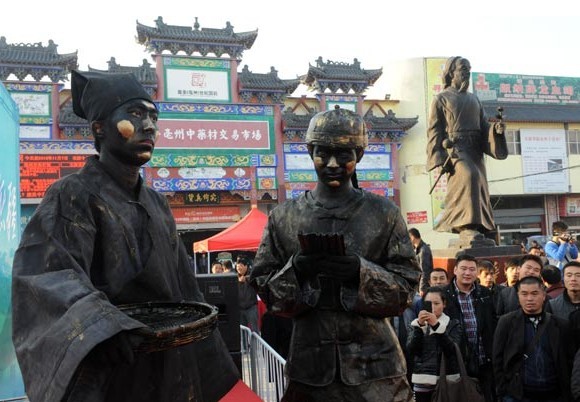Models dressed as ancient pharmacists attract the attention of medicine dealers at Bozhou Traditional Chinese Medicine Market in Bozhou, Anhui province, on Thursday. ZHANG YANLIN / FOR CHINA DAILY  
