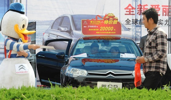 Potential buyers look at a car at an auto show in Lianyungang, Jiangsu province. In October, more than 1.5 million vehicles were sold in China. [GENG YUHE/CHINA DAILY]  