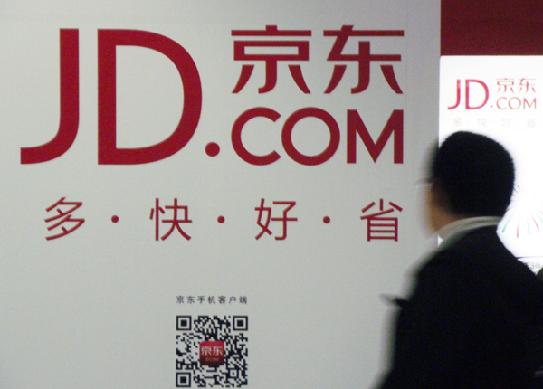 A man walks past an adevertisement for JD.com in Nanjing, capital of East China's Jiangsu province on June 12, 2013.[Zhen Huai / Asianewsphoto] 
