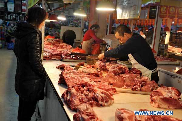 A consumer selects pork at a market in Changchun, capital of northeast China's Jilin Province, Nov. 9, 2013. China's consumer price index (CPI), a main gauge of inflation, grew 3.2 percent year on year in October, up from 3.1 percent in September, the National Bureau of Statistics said on Saturday. (Xinhua/Zhang Nan)