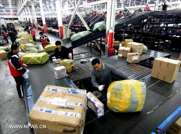 Workers sort outpiled-up packages at YTO Express' sorting center in east China'sShanghai Municipality, Nov. 9, 2013. As the Chinese grassroots'self-proclaimed Singles' Day, which falls on November 11, gainspopularity, the country's e-commerce websites have grasped thechance to make money. The surging package volume caused greatpressure for many express delivery companies. (Xinhua/Chen Fei)