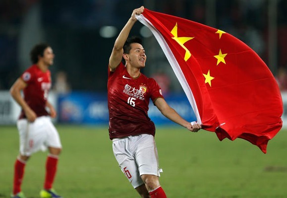 Huang Bowen (16) of China's Guangzhou Evergrande celebrates with the national flag after winning the AFC Champions' League at Tianhe stadium in Guangzhou on Saturday. Bobby Yip / Reuters  