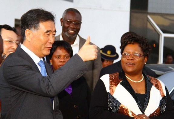 Chinese Vice-Premier Wang Yang gestures upon his arrival as Zimbabwe's Vice-President Joyce Mujuru (R) is seen in Harare, Zimbabwe, on May 21, 2013. Wang Yang arrived in Harare on Tuesday, starting an official visit to Zimbabwe, the first leg of his African trip from May 21 to 25 to boost China's relations with the continent. [Photo/Xinhua]