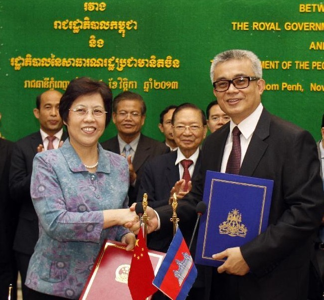Cambodian Finance Minister Aun Porn Moniroth (R) shakes hands with Chinese Ambassador to Cambodia Bu Jianguo during the signing ceremony in Phnom Penh, Cambodia, Nov. 14, 2013. The Chinese government on Thursday signed an agreement to provide a free-interest loan of 200 million Renminbi (33 million U.S. dollars) to Cambodia for social and economic development projects. (Xinhua/Sovannara)