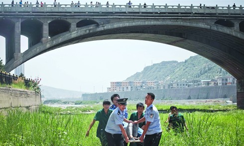 Police rush an elderly man to hospital who, heavily in debt, had jumped from Erlangshan Bridge in an attempt to commit suicide. Photo: Zhou Pinglang/Tencent News
