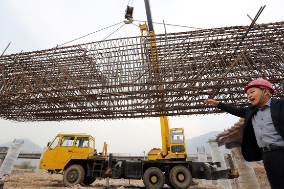 Workers build a bridge at a construction site Linzhou, Henan province. Thirteen provincial-level regions reported that GDP growth in the first three quarters was below their full-year targets. Provided to China Daily  
