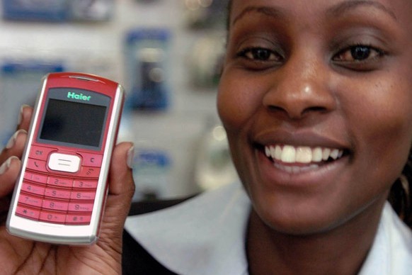 A sales assistant shows a cell phone made by Haier, a widely known Chinese brand, in Nairobi, Kenya, in 2005. More and more products with the Made in China label, from shoe polish to trucks, have become part of daily life in Africa. Provided by Xinhua