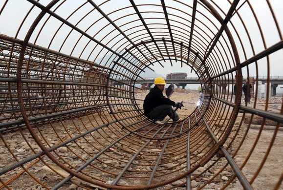 A worker welds a steel frame for a bridge under construction in Linzhou, Henan province. The National Development and Reform Commission is expected to work out an annual target list to implement reform initiatives mapped out at a key leadership meeting earlier this month. Bi Xingshi / For China Daily 