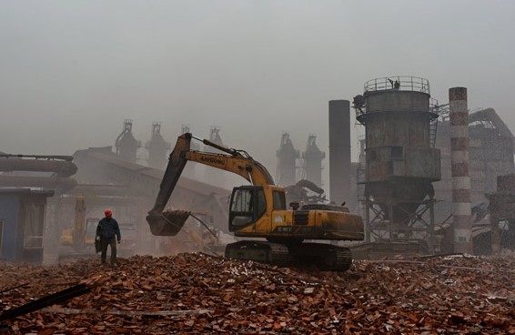 Workers in Tangshan, Hebei province, clear the rubble from a demolished 450-cubic-meter furnace on Sunday at the start of the provinces campaign to curb pollution and eliminate excessive iron production. Yang Shiyao / Xinhua
