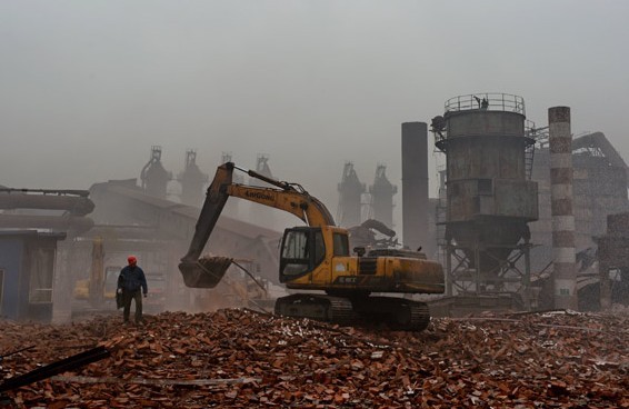Workers in Tangshan, Hebei province, clear the rubble from a demolished 450-cubic-meter furnace on Sunday at the start of the provinces campaign to curb pollution and eliminate excessive iron production. Yang Shiyao / Xinhua