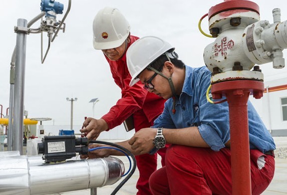 Two employees from PetroChina work on a natural gas pipeline. [Wang Fei / Xinhua]  