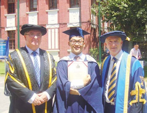 Professor Nigel Weatherill (right), vice-chancellor of Liverpool John Moores University, and Professor Ian Gow (left), principal of the Sino-British College, with Zhou Xinqiao, who completed his bachelor's degree at SBC last year and recently earned a master's degree with distinction at Imperial College London. Provided to China Daily