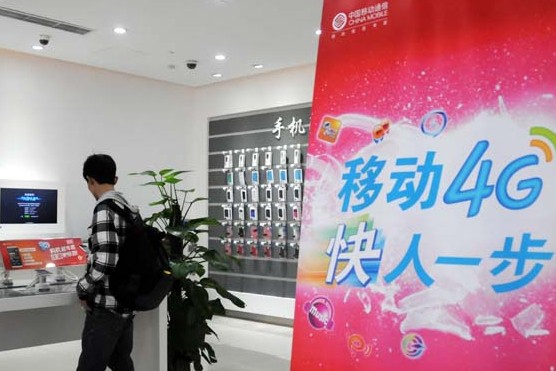 A customer considers a new 4G phone in a China Mobile service hall in Beijing.[Photo/China Daily]   