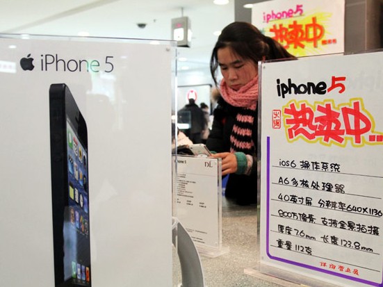 A customer considers an iPhone 5 in a shop in Xuchang, Henan province. China Mobile, together with two other Chinese carriers, received licenses on Wednesday to offer commercial 4G telecom services. [Photo / China Daily]