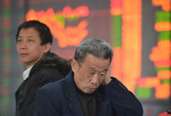 Two men watch the stock market at a broker's office in Fuyang, Anhui province on Friday. The IPO reform plan, which was released on Nov 30, was widely welcomed by the market. Lu Qijian / For China Daily