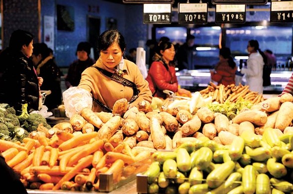 A customer shops for vegetables at a supermarket in Xuchang, Henan province. In November, food prices went up 5.9 percent year-on-year, with vegetable prices up 22.3 percent, according to the National Bureau of Statistics. [Photo / China Daily]