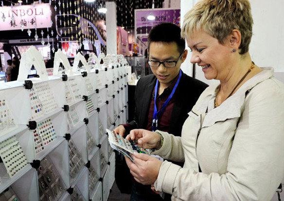 A foreign merchant looks over the goods at a fair in Yiwu, Zhejiang province. Global demand for Chinese products is likely to improve in 2014, according to experts. [Photo / China Daily]