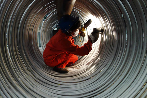 A worker checks stainless-steel cable at a base in Dalian, Liaoning province. The growth rate for steel demand will fall from 6.3 percent in 2013 to 3.2 percent next year. Liu Debin / for China Daily