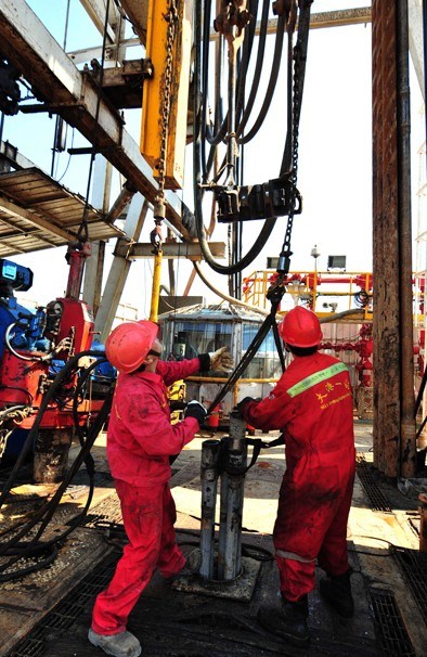 Workers man an oil drill at the Dagang oilfield in Tianjin. A study has found that China will consume 590 million metric tons of petroleum in 2020 and about 690 million tons by 2030. LIU HAIFENG / XINHUA  