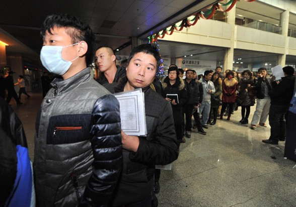 Local residents stand in line waiting to proceed with transactions of car sales in a used car market in Tianjin on Dec 15, a day before the city began imposing quota on its new car plates. [Photo / Xinhua]