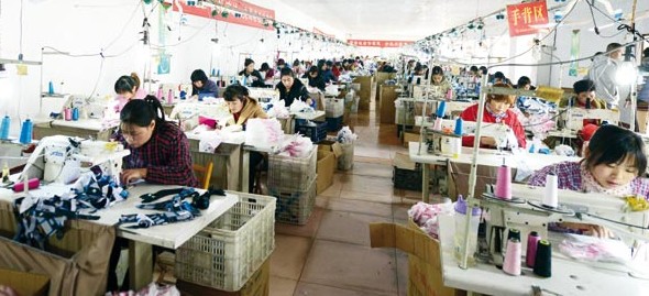 Workers make gloves at one of the 11 glove-producing factories run by Meng Hongjian. [Photo / China Daily]