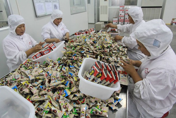 Workers pack candy at a subsidiary of Shanghai Golden Monkey Food Joint Stock Co Ltd in Henan province. The Hershey Co plans to acquire 80 percent of SGM, with the transaction expected to wrap up in the second quarter of 2014. Provided to China Daily  