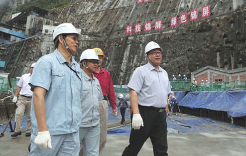 Wang Huisheng (right), chairman of the State Development and Investment Corporation, inspects construction work on the Jinping 1 Hydropower Station in September. The double curvature arch dam is 305 meters high, making it the highest of its kind in the world. Concrete pouring of the dam is expected to be completed on Monday. Provided to China Daily  