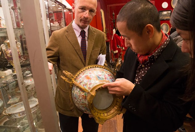 A Chinese examines a porcelain vase at one of the oldest French auction houses, Drouot. Li Xiang / China Daily  