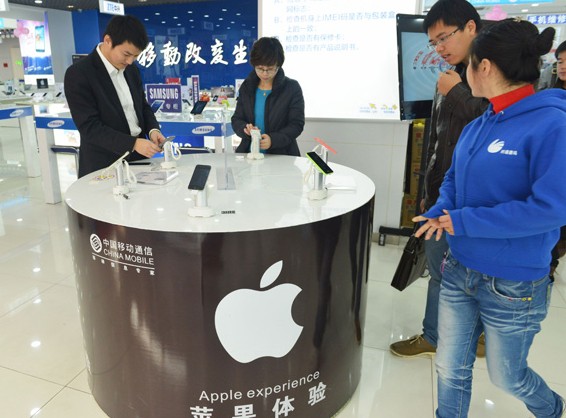 Customers choose iPhone handsets at a China Mobile Ltd branch in Hangzhou, Zhejiang province. China Mobile and Apple Inc have signed a multiyear agreement to bring the latest Apple smartphone models to the mainland market. Long Wei / For China Daily  