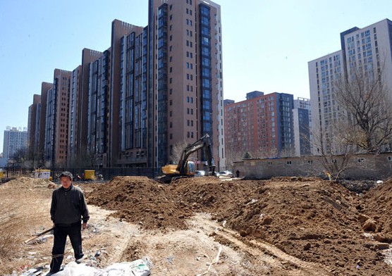 Workers clear out a plot of land in Beijing's Chaoyang district. Beijing, Shanghai, Guangzhou and Shenzhen sold a combined 501.5 billion yuan ($82.6 billion) worth of land this year as of Dec 20. Provided to China Daily