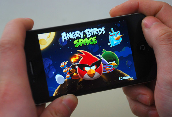 A man plays Angry Birds game on his mobile phone in Taizhou, Zhejiang province in this March 24, 2012 file photo 