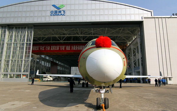 One of the pairs of China's first domestically produced regional jets, the 90-seat ARJ21-700, is pictured in front of a hangar of the Commercial Aircraft Corp of China (COMAC) on Dec 30, 2013 in Baoshan District, Shanghai. [Photo / dfic.cn]