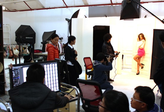 Staff members of Moonbasa take photos for a model on Dec 23, 2013 in Guangzhou. [Liu Zheng/chinadaily.com.cn] 