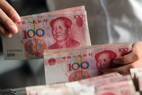 MONEY MATTERS: A clerk from a rural credit cooperative in Linyi, Shandong Province, counts banknotes. [Photo/bjreview.com.cn]   