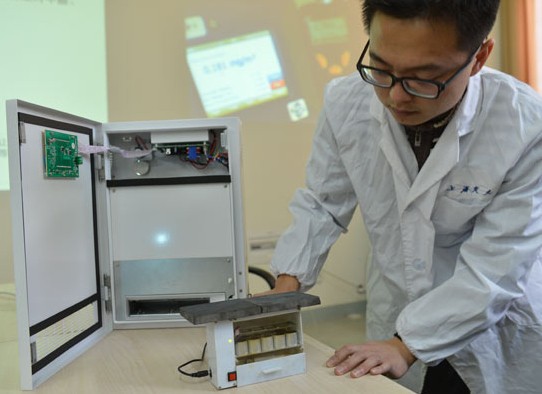 A member of the Shanghai Jiao Tong University research team that invented a new air-purifying device demonstrates the machine. The devices technology can prevent secondary pollution that existing air purifiers can create if not used properly. Du Xin / for China Daily  