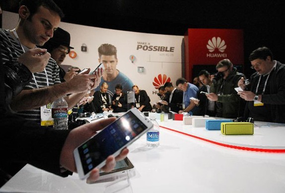 Journalists try the latest smart phone of China's Huawei during an Exhibitor Press Release of the 2014 international CES in Las Vegas, the United States, Jan 6, 2014.[Photo/Xinhua]  