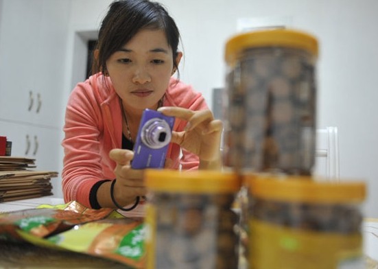 The owner of an online food shop takes a photo of her products for uploading onto the Internet in Hangzhou, Zhejiang province. A ruling is expected to make online food and medicine safer. Hu Jianhuan / for China Daily  