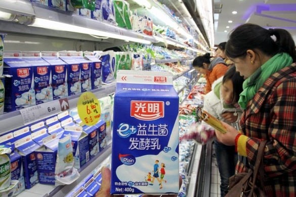 Shoppers choose dairy products at a supermarket in Xuchang, Henan province. Bright Food Group plans to list its newly acquired assets in foreign countries, including Manassen Foods in Australia and cereal maker Weetabix in Britain. [Photo / China Daily]