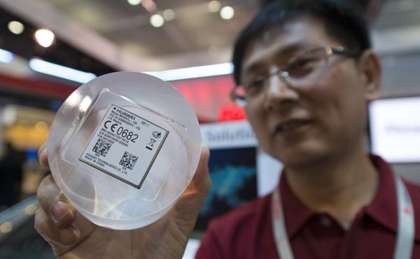 A Huawei worker displays a 4G communications module for cars at an electronic products show in Las Vegas, US on Jan 8, 2014. [Photo/Xinhua] 