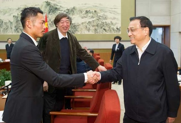 Premier Li Keqiang greets badminton Olympic and world champion Lin Dan, as writer Feng Jicai looks on, during a forum in Beijing on Friday. Ten representatives shared their views on the governments work in 2013 and made suggestions to improve the Government Work Report. Huang Jingwen / Xinhua   