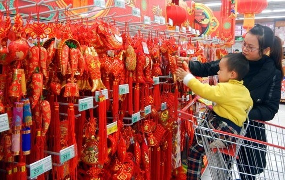 A customer chooses decorations for the Lunar New Year, which starts on Jan 31, at a supermarket in Suzhou, Jiangsu province. Consumption contributed 50 percent to GDP growth in 2013, 1.8 percentage points lower than in 2012. Wang Jiankang / For China Daily  