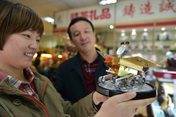 A woman looks at a 1:12 scale model of China's Yutu moon rover in a shop at Yiwu International Trade City, Zhejiang province, Dec 3, 2013. [Photo/Xinhua]
