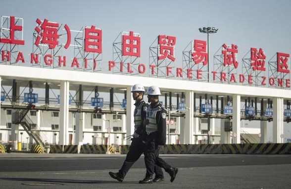 Customs officers walk near a checkpoint at the China (Shanghai) Pilot Free Trade Zone. Provided to China Daily