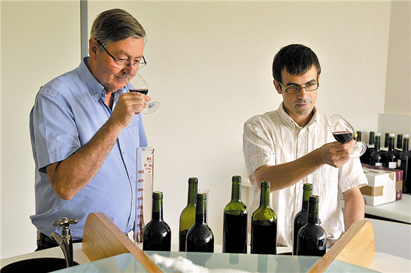 Bernard Ducourt (left), former general manager of the family-owned company Vignobles Ducourt, and his nephew Jeremy in the tasting room, hard at work blending the family's 2009 vintage red wine. Jon Wyand / for China Daily