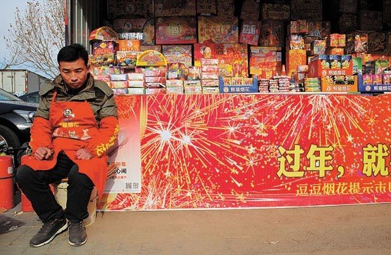 A salesman waits for customers at a fireworks retail outlet in Beijing��s Chaoyang district on Saturday. WANG JING / CHINA DAILY  