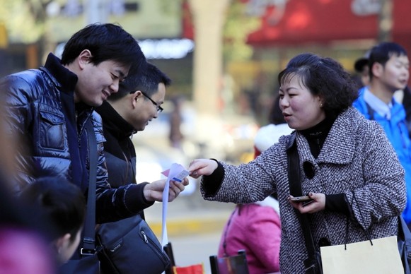 An enterprise recruitment representative introduces employment opportunities to job seekers at a job fair in Jiujiang, Jiangxi province, on Thursday. Zhang Haiyan / for China Daily   
